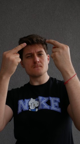 Model prezentuje czarną koszulkę "F*CK KITTY - NIEBIESKA" z nadrukiem z przodu