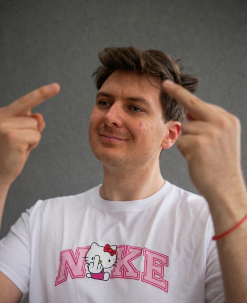 Model prezentuje białą koszulkę "F*CK KITTY - RÓŻOWA" z nadrukiem z przodu