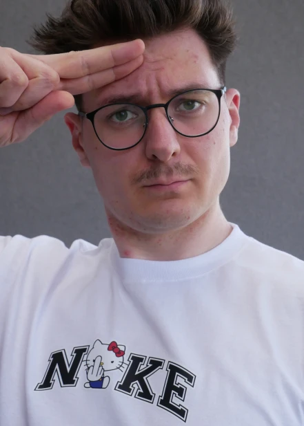 Model prezentuje białą koszulkę "SOFT REBEL" z nadrukiem z przodu hello kitty fuck
